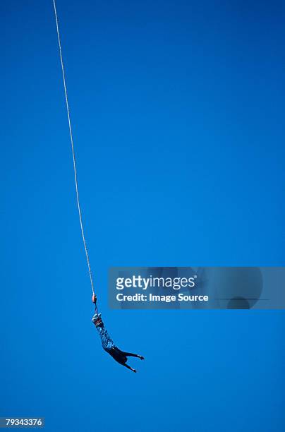 a person bungee jumping - bunjee jumping stock-fotos und bilder