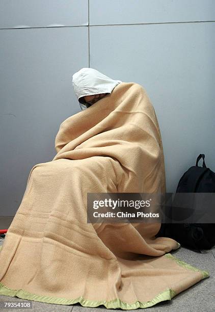 Passenger stranded due to heavy snow, rests in a blanket on January 28, 2008 in Guangzhou of Guangdong Province, China. The worst prolonged snow,...