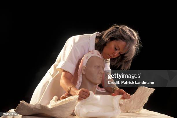 Anthropological sculptress Elisabeth Daynes uses the finished clay sculpture of Otzi's skull to make a contact-copy in white silicone with plaster...