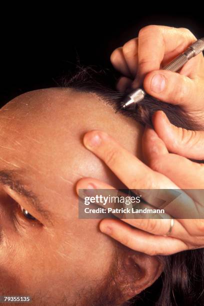 The skin of a rough silicone model of Otzi's head is tinted by anthropological sculptress Elisabeth Daynes before eyelashes, eyebrows and a wig are...