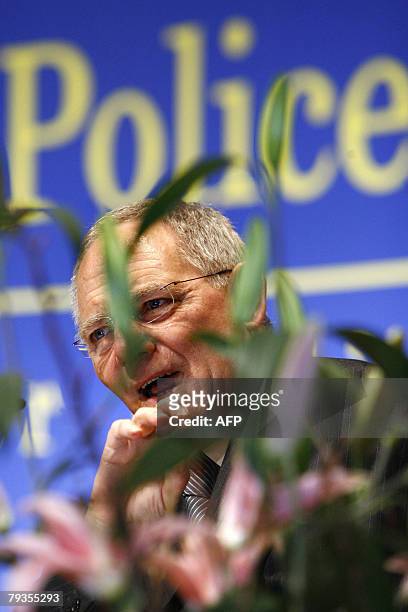 German Interior minister Wolfgang Schaeuble is seen through flowers as he gives his opening speech of the 11th European Police Congress also attended...