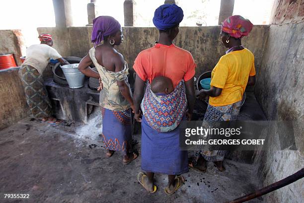 Christophe PARAYRE Burkinabe women from the Ragussi association gather 14 January 2008 around cauldrons used to process shea nuts at the organic shea...