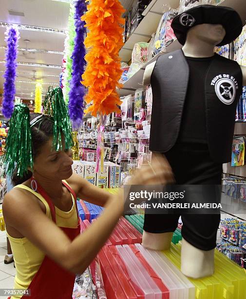 Shop assistant Alexandra Rodrigues puts a police costume, inspired in the film "Tropa de Elite" on display at the shop in Rio de Janiero on January...