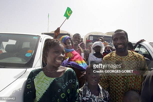 Negro-Mauritanian Ibrahima Ba waist to disembark with his family as they arrive in Rosso 29 January 2008. Almost two decades after ethnic conflict...