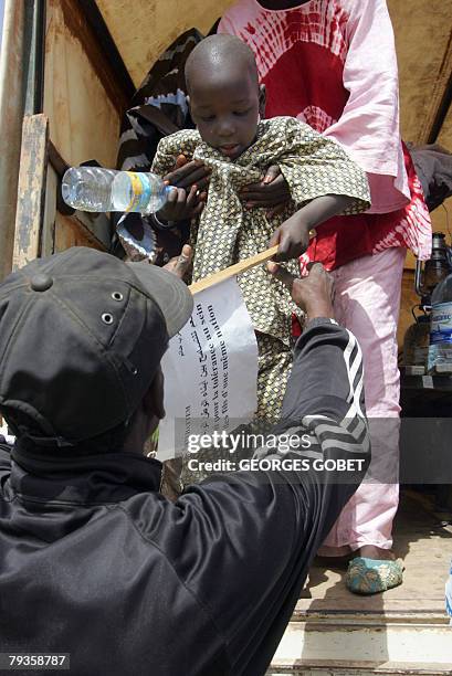 Negro-Mauritanian refugee infant is helped from a truck on his arrival with his mother in Rosso 29 January 2008. Almost two decades after ethnic...