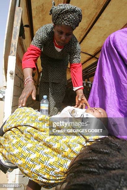 Negro-Mauritanian refugee infant is helped from a truck on his arrival with his mother in Rosso 29 January 2008. Almost two decades after ethnic...