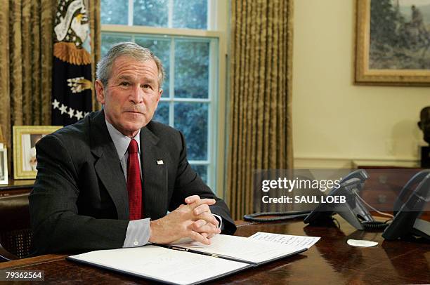 President George W. Bush sits at his desk after signing an Executive Order titled "Protecting American Taxpayers from Government Spending on Wasteful...