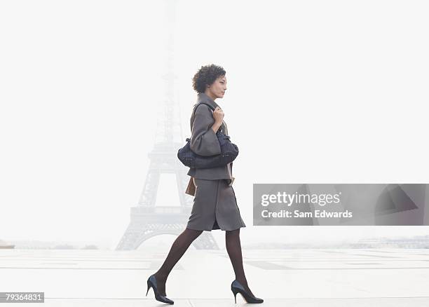 geschäftsfrau zu fuß in plaza von eiffelturm - white purse stock-fotos und bilder