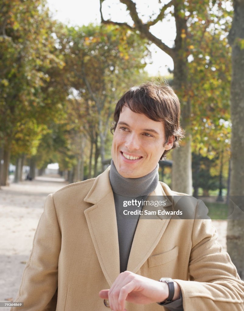 Businessman outdoors in park checking the time