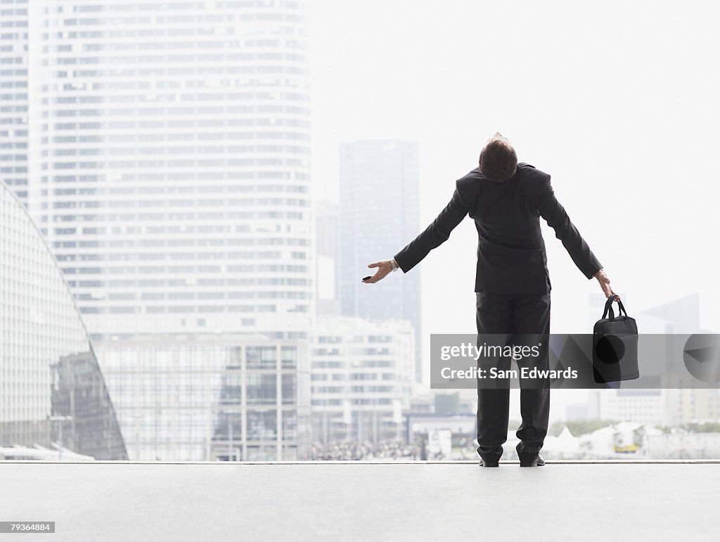 Homem de Negócios ao ar livre no topo da Escadaria com os braços esticados