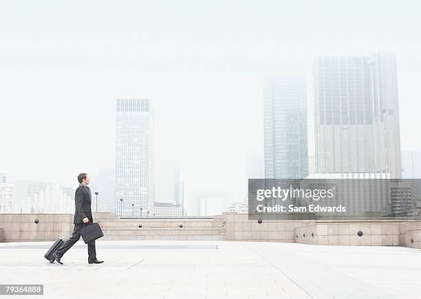 businessman outdoors walking with luggage - överexponerad bildbanksfoton och bilder
