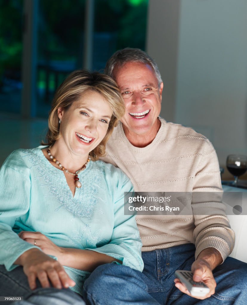 Couple in living room watching television