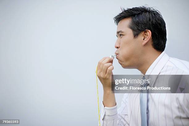 businessman indoors blowing whistle - informante papel humano - fotografias e filmes do acervo