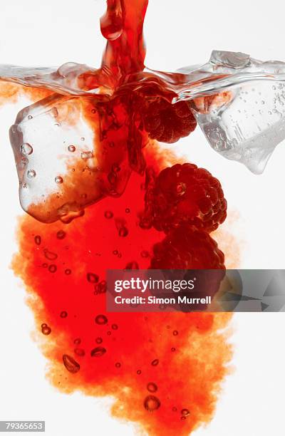 red liquid pouring into glass with raspberries - raspberry cocktail stock pictures, royalty-free photos & images