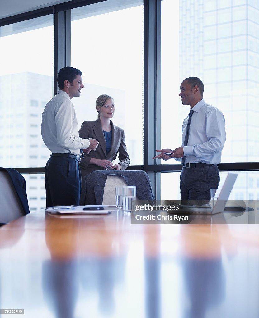 Three businesspeople standing in a boardroom