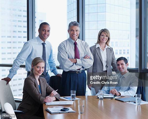 cinque uomini d'affari in una sala riunioni guardando la telecamera - five people foto e immagini stock