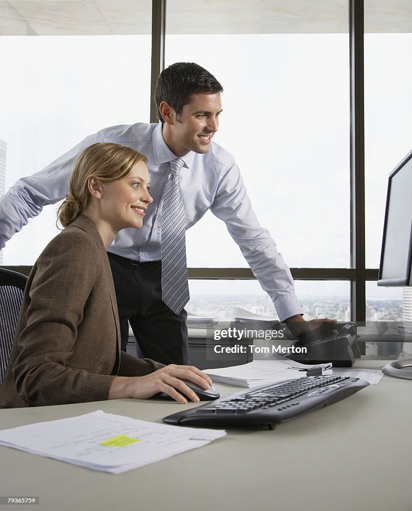 Empresário e Mulher de Negócios em um escritório com um computador