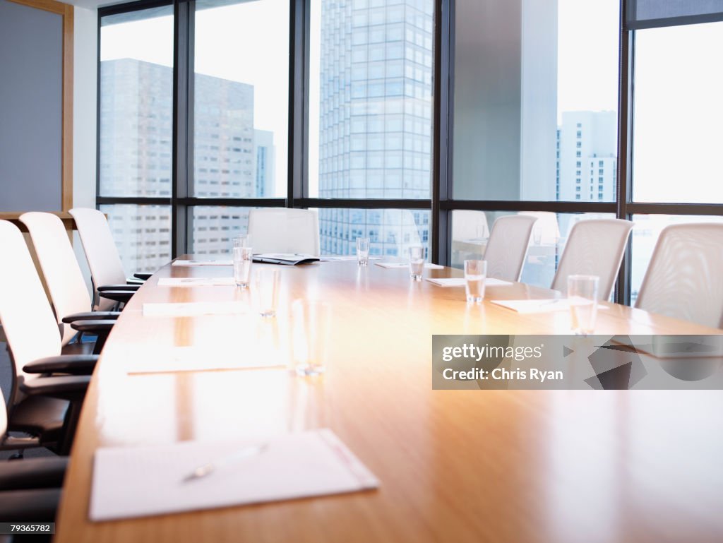 Empty boardroom table with paperwork