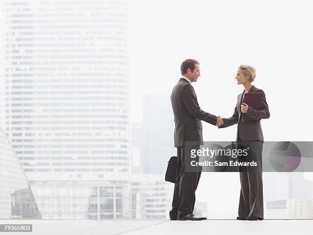 two businesspeople outdoors shaking hands at top of staircase - the paris agreement stock pictures, royalty-free photos & images