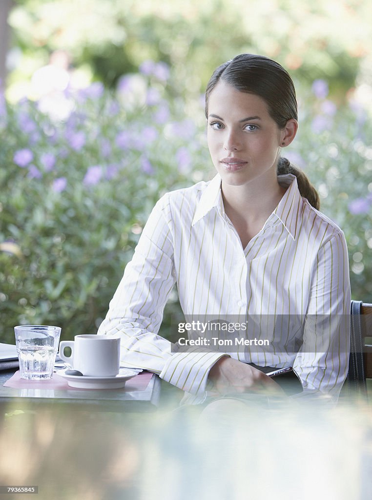 Businesswoman at outdoor patio table looking at camera