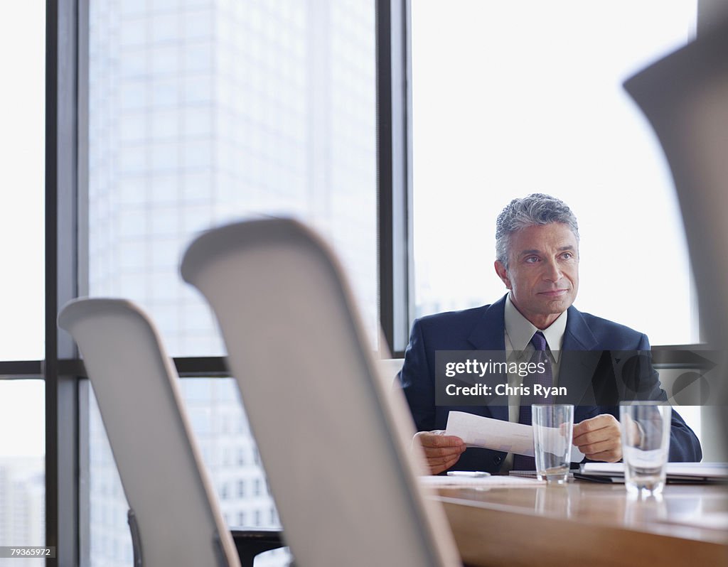 Businessman in boardroom with paperwork