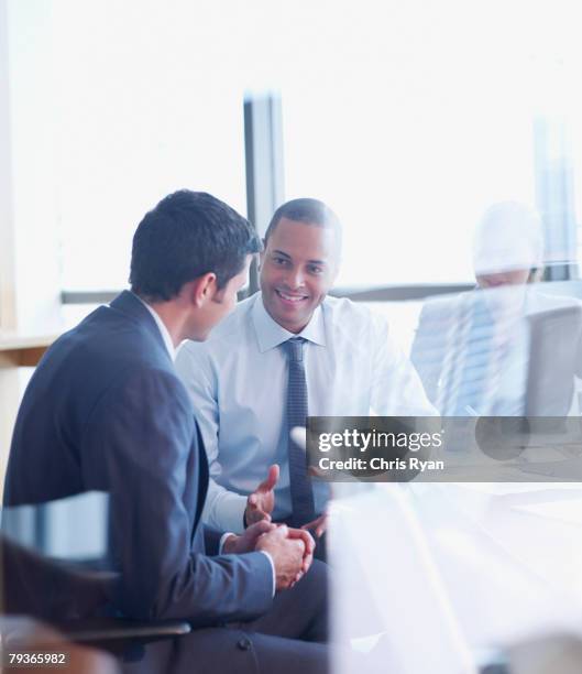 tres hombres de negocios en la sala de juntas a vidrio - entrevista acontecimiento fotografías e imágenes de stock