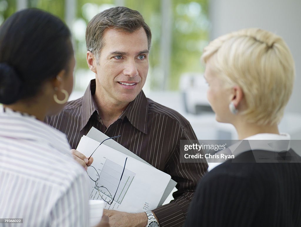 Three businesspeople in office talking