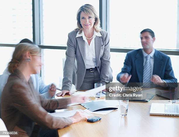 four businesspeople in boardroom with one in focus - business meeting blurry stock pictures, royalty-free photos & images