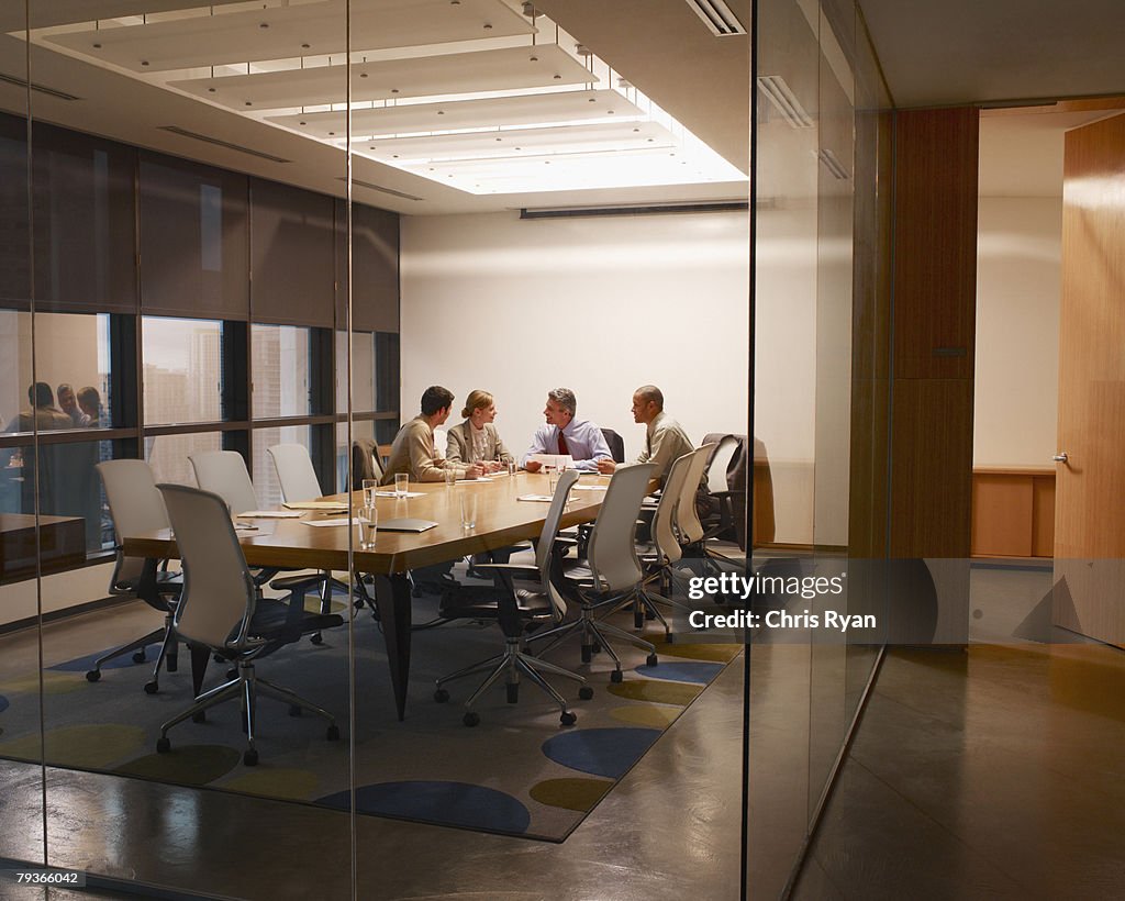 Four businesspeople in boardroom working