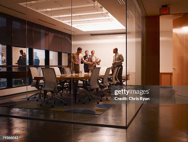 quatro empresários na sala de reuniões a preparar para sair - four bussines man at office imagens e fotografias de stock