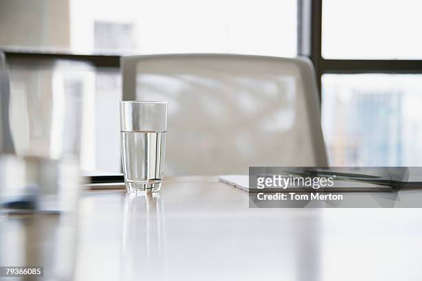empty boardroom chair with notepads and glasses of water on table - conference table and chairs stock pictures, royalty-free photos & images
