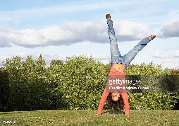 woman outdoors doing a cartwheel - cartwheel stockfoto's en -beelden