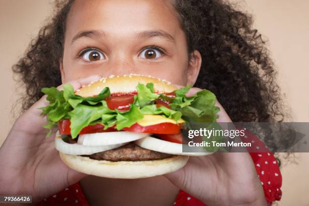 jeune fille à l'intérieur de manger un hamburger - burger portrait photos et images de collection