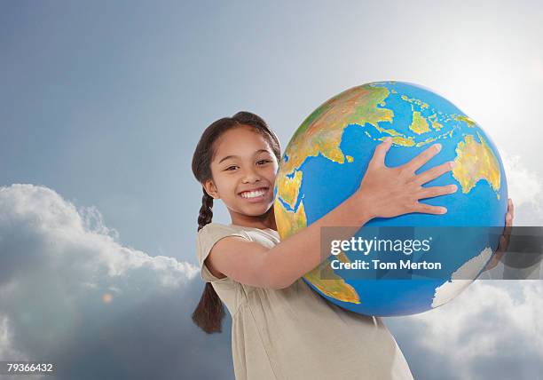 young girl outdoors holding a large globe - world children day stock pictures, royalty-free photos & images