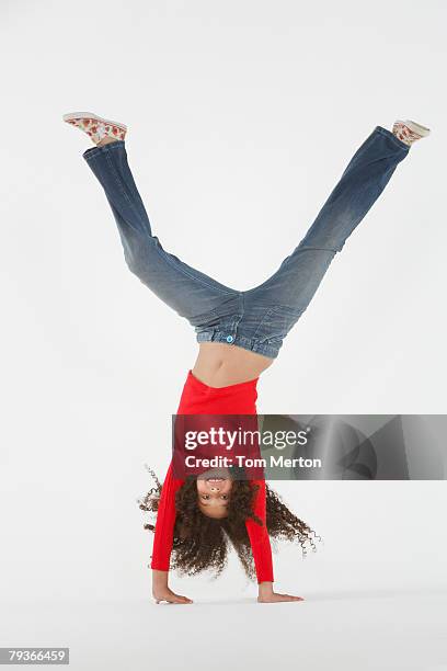 young girl doing cartwheel indoors - cartwheel stockfoto's en -beelden