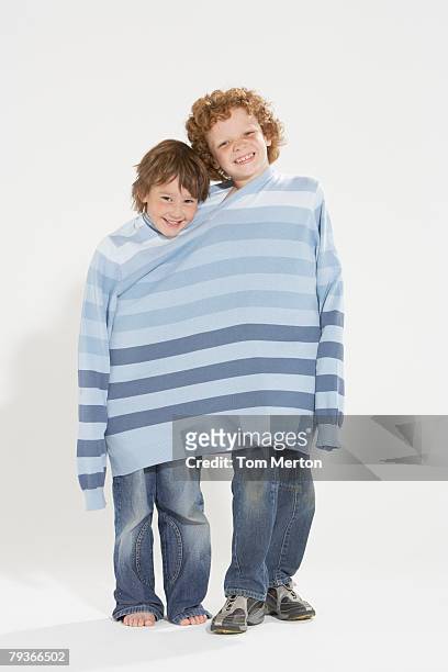 zwei jungen im freien mit dem gleichen pullover - passt nicht stock-fotos und bilder