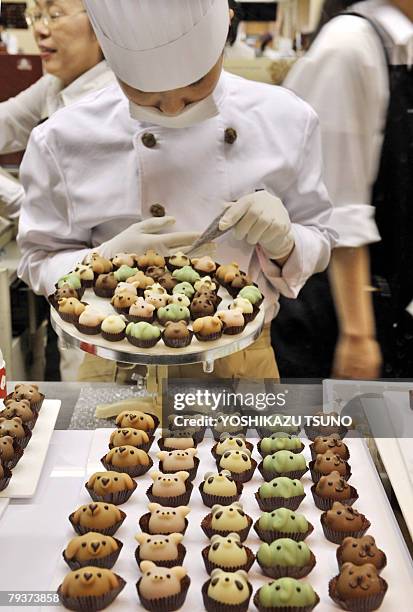 Japan's sweet shop Goncharoff chocolatier puts the final touch to animal shaped chocolates with their eyes, noses and mouths at Takashimaya...