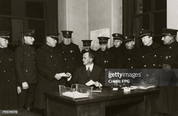 Members of the New York Citizen's Police receive the night's orders at headquarters, circa 1930. From left to right, Captain J. J. McDonald , Captain...