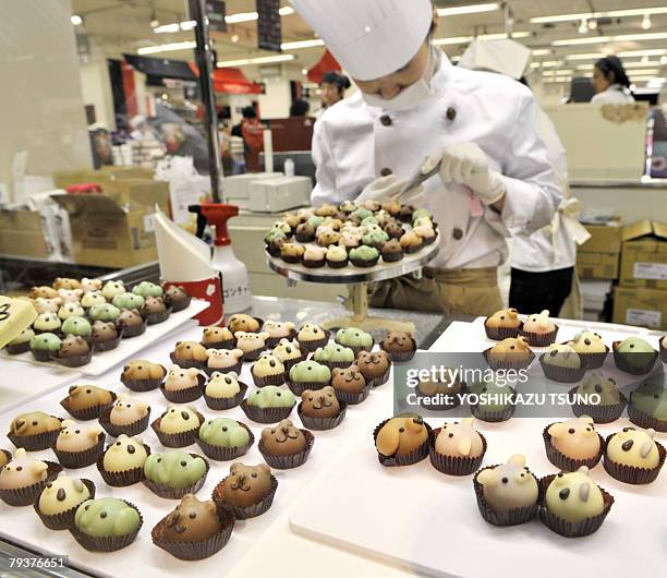 Japan's sweet shop Goncharoff chocolatier puts the final touch to animal shaped chocolates with their eyes, noses and mouths at Takashimaya...