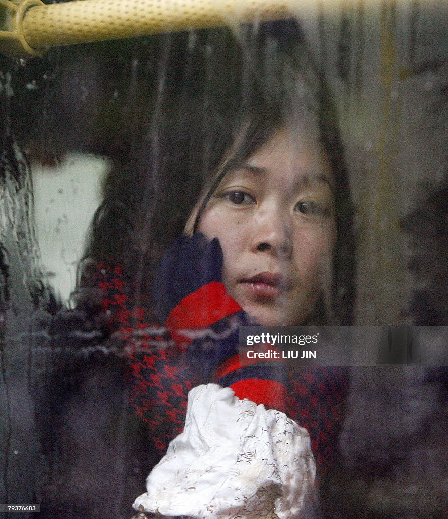 A woman looks out from the window of a c