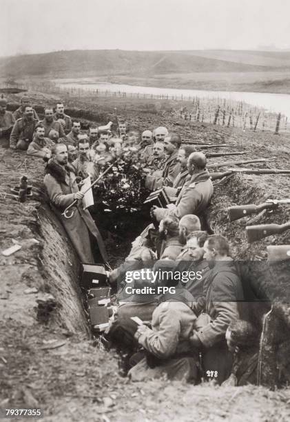 German troops singing around a Christmas tree in their trench on the Eastern Front during World War I, circa 1915.