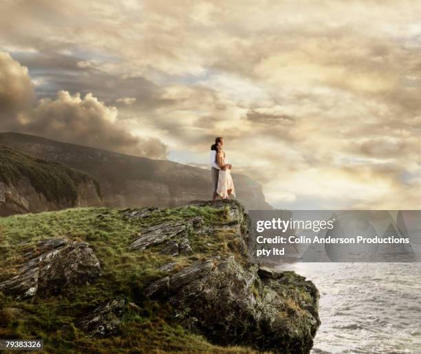 pacific islander couple hugging on cliff over ocean - cliff side stock pictures, royalty-free photos & images