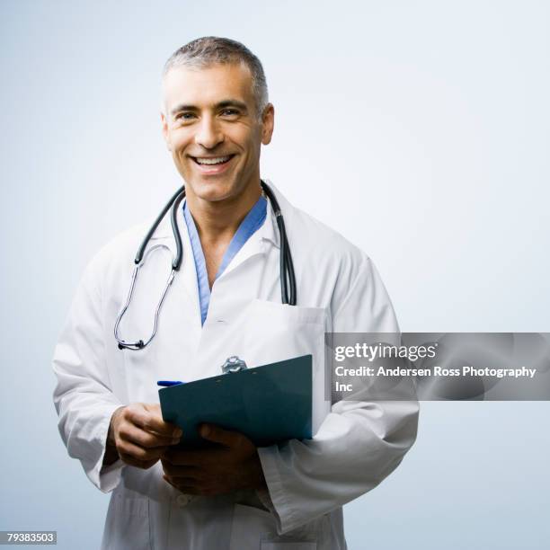 middle eastern male doctor holding chart - paramedic portrait stock pictures, royalty-free photos & images