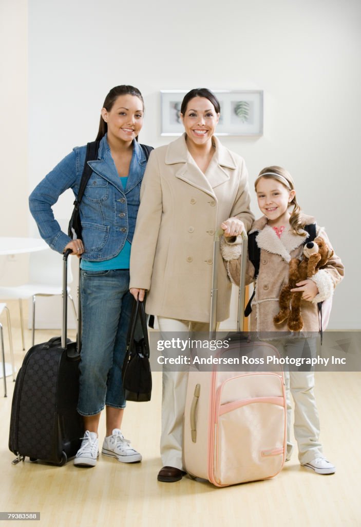 Hispanic mother and daughters with suitcases