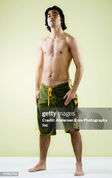 mixed race man wearing bathing suit - mixed race man standing studio stockfoto's en -beelden