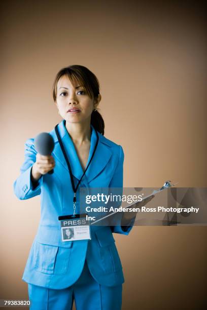 pacific islander female reporter holding microphone - woman interview stock-fotos und bilder