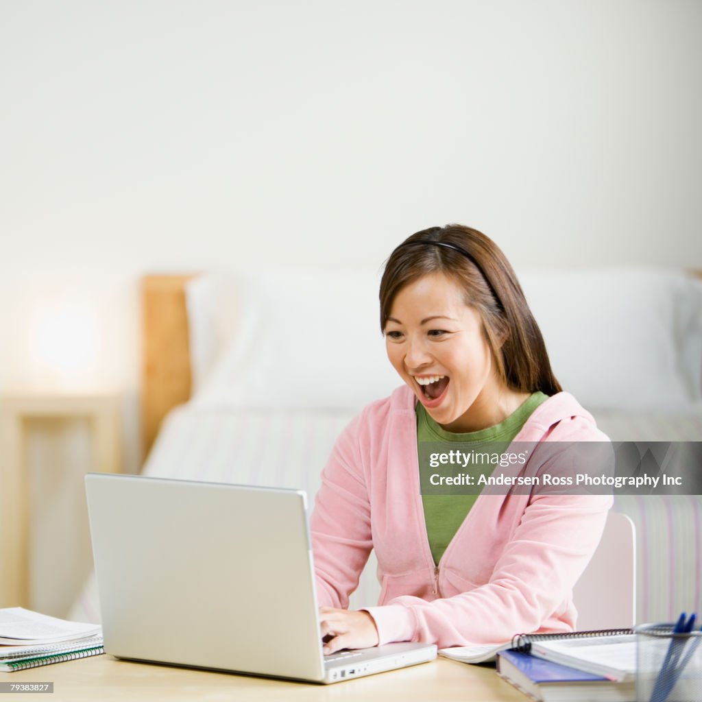 Asian woman typing on laptop