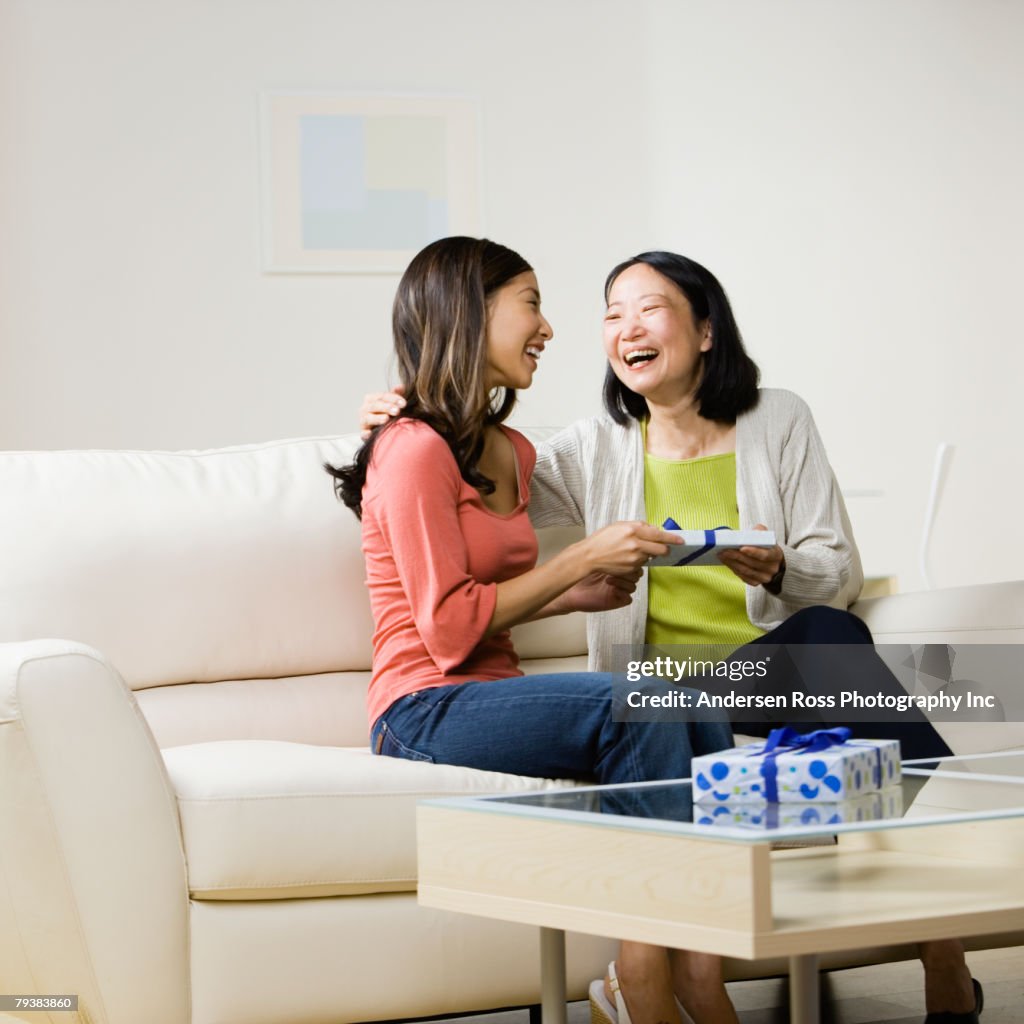 Asian mother and adult daughter exchanging gift