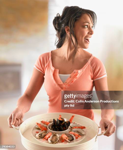 hispanic woman carrying platter of seafood - seafood platter bildbanksfoton och bilder