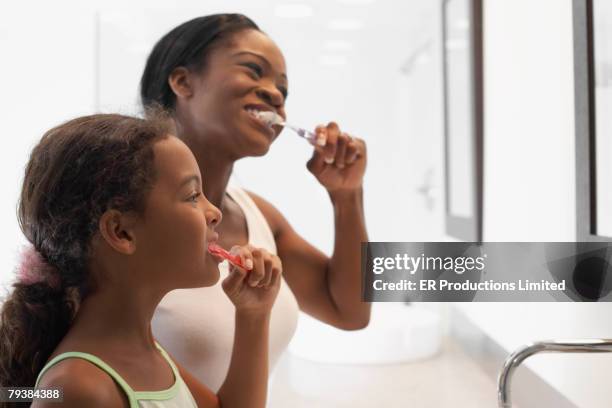 african american mother and daughter brushing teeth - brushing teeth ストックフォトと画像